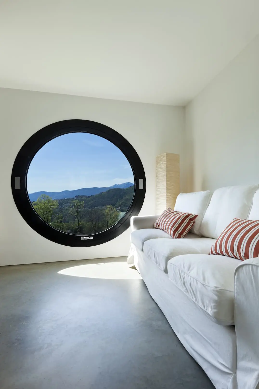 Таванска стая с кръгъл прозорец и под облицован с варовиков разтвор.