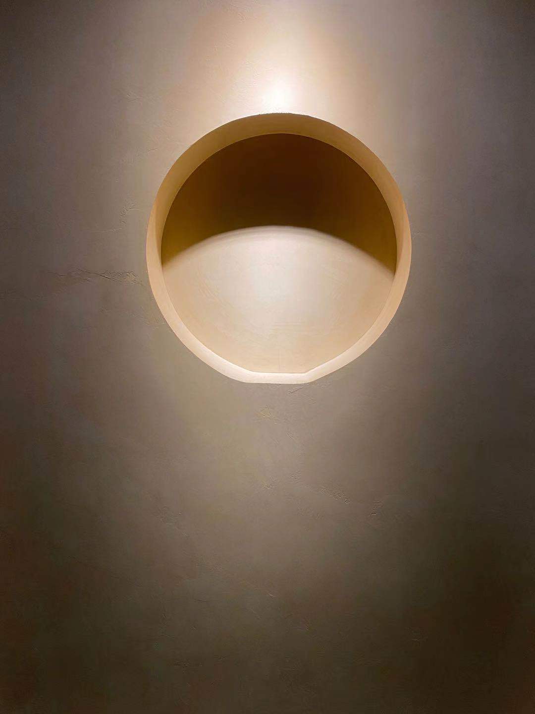 Микроцемент на стената на дом в минималистичен стил с осветление, което подчертава покритието