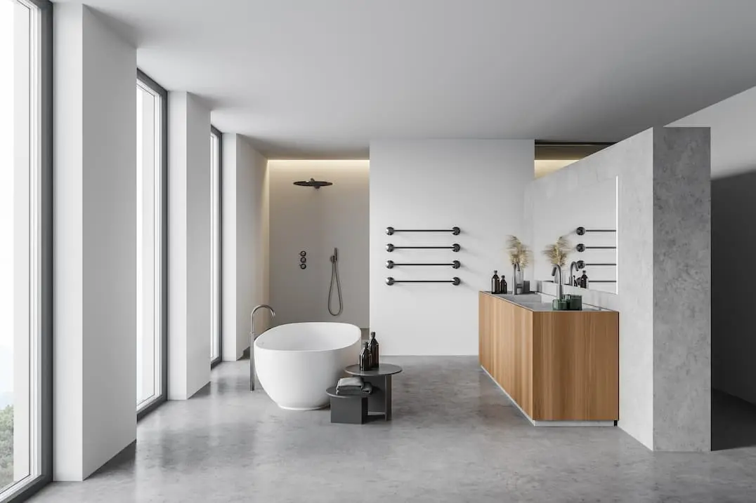Koupelna s velkými okny a vanou uprostřed, dekorovaná mikrocementovým podlahovým vytápěním