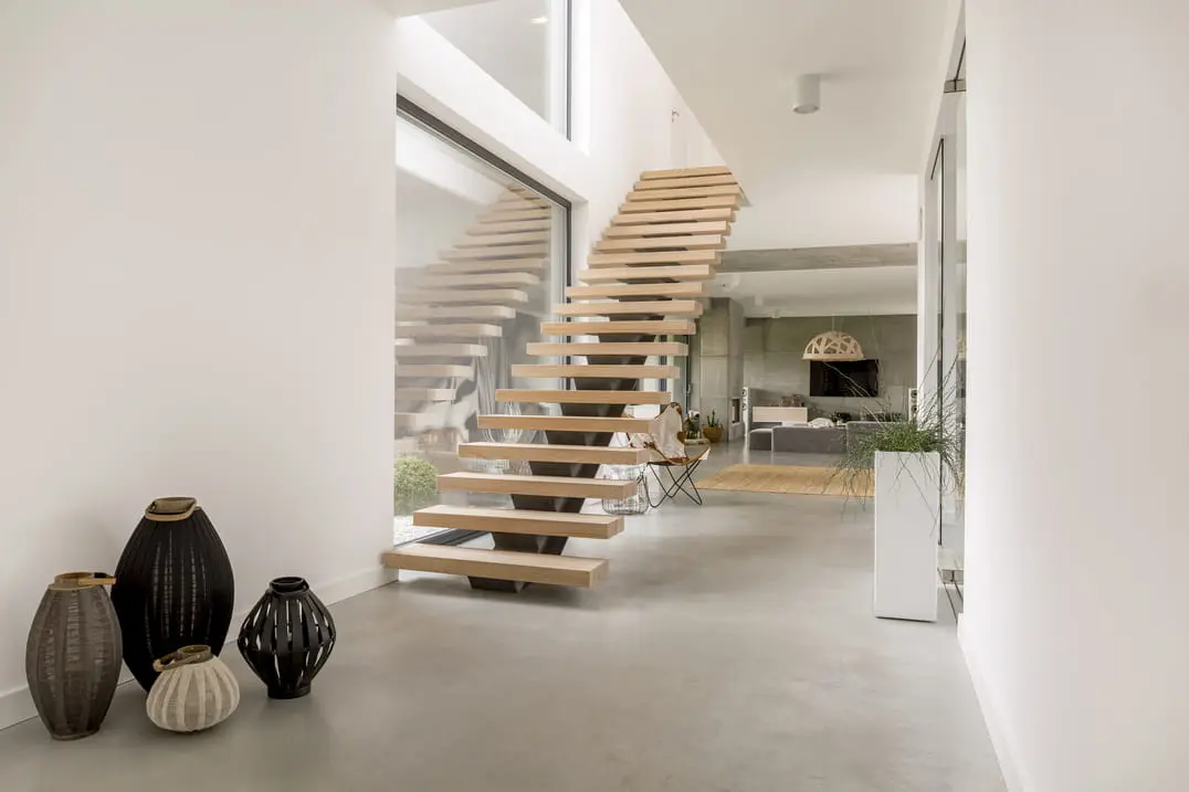 Dřevěné schodiště v domě s podlahou z mikrocementu