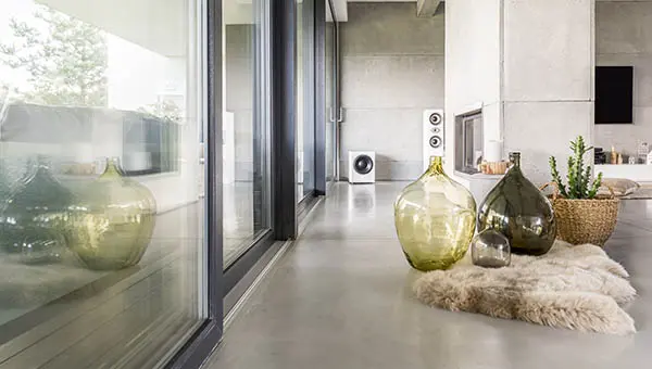 Mikrocementbelægning på gulvet i et hus med udsigt til en have og dekoreret i en minimalistisk stil