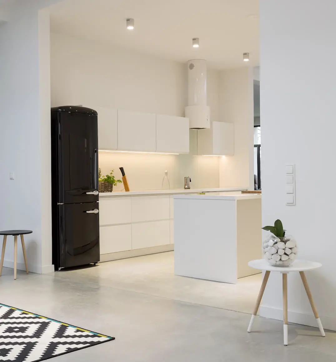 Living room with entrance to a small kitchen decorated in light tones