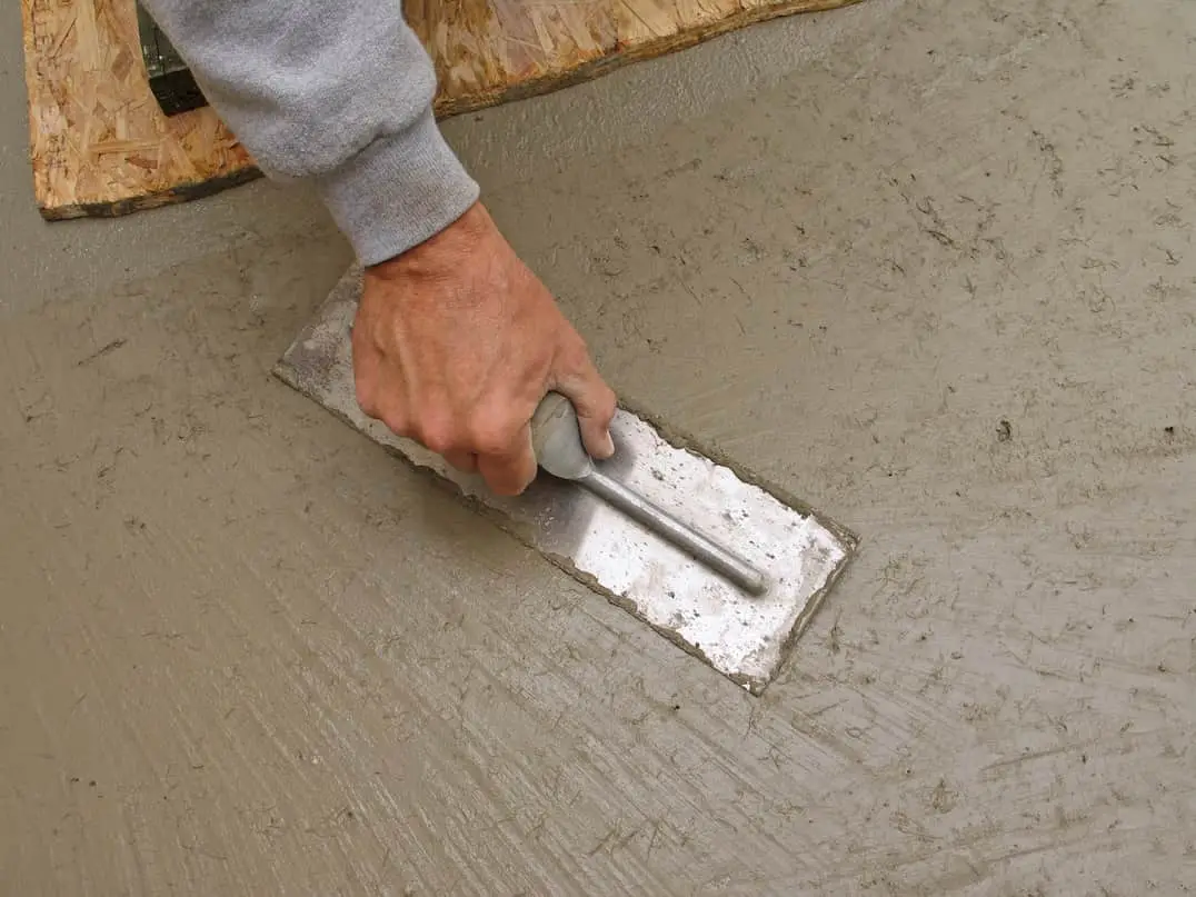 Professional applying stamped concrete for swimming pools