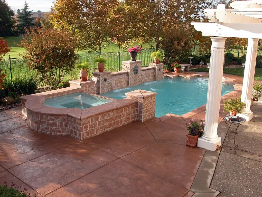 Country house with floral style garden and pool with surrounding stamped concrete floor