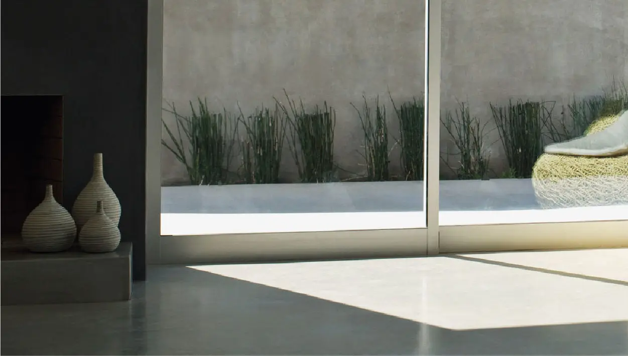 Microcement protective wax applied on the floor of a house with views to the outside and gray tones