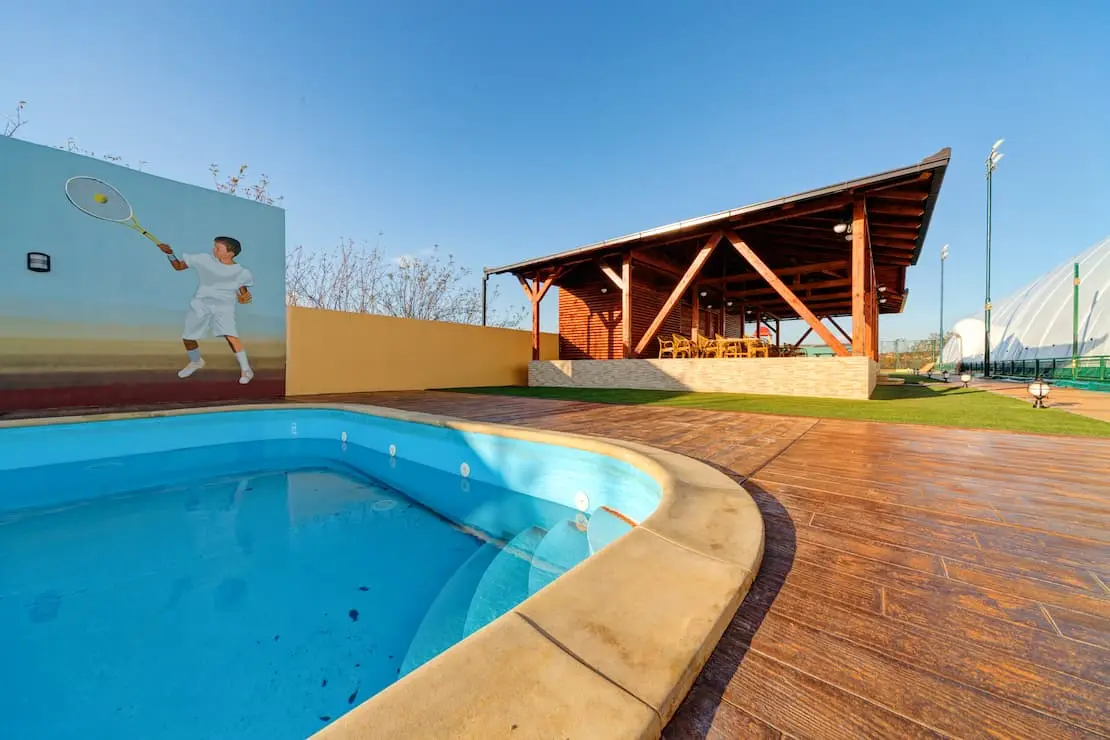 Tennis club with swimming pool and surrounding floor of wood-like imprinted concrete.