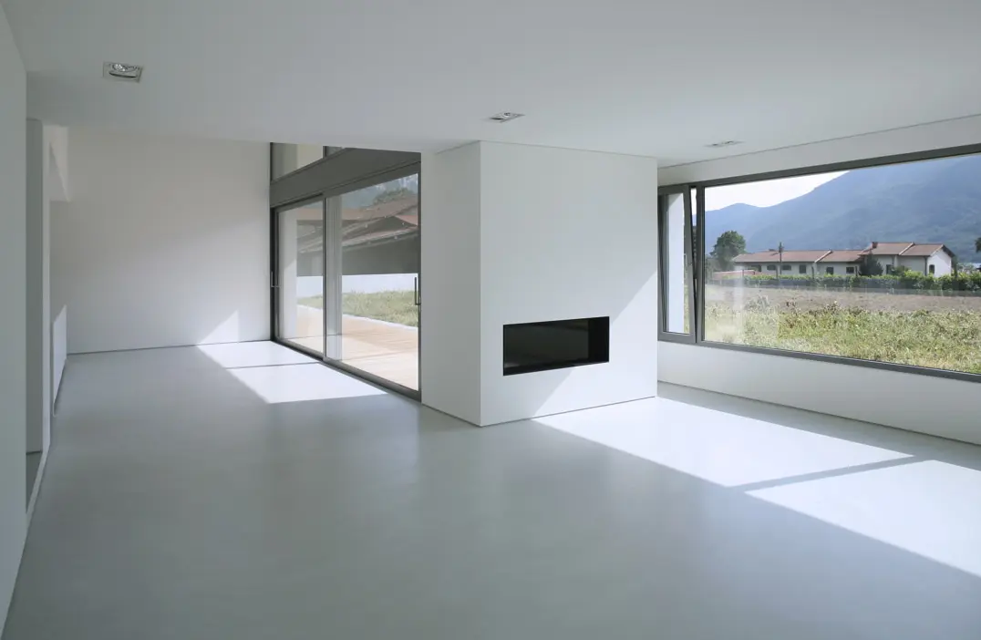 Microcement floor in an empty living room with countryside views
