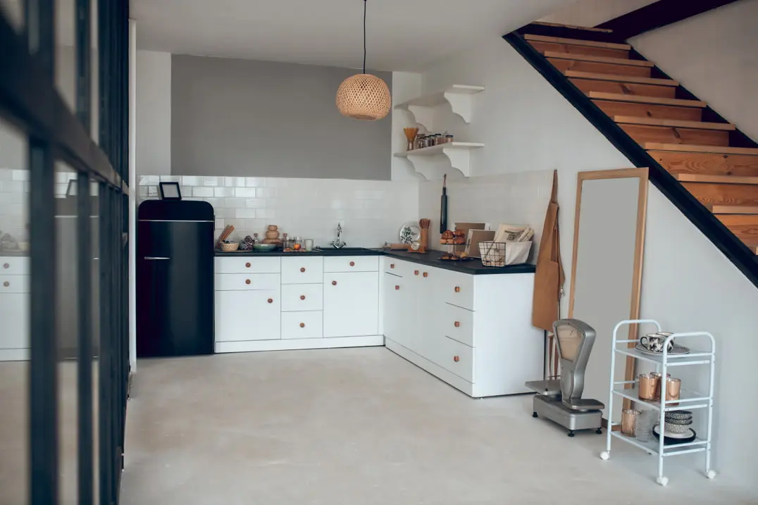 Suelo de microcemento en una cocina equipada con azulejos en las paredes y decorada con un estilo clásico