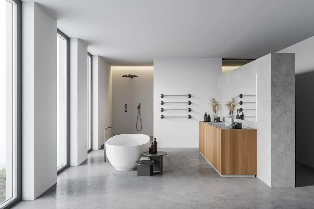 Baño con grandes ventanales y bañera en medio, decorado con suelo radiante de microcemento