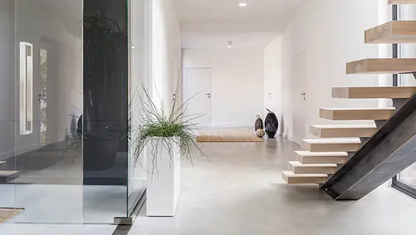 Revestimiento de microcemento en un pasillo largo que conecta con la planta superior de la vivienda