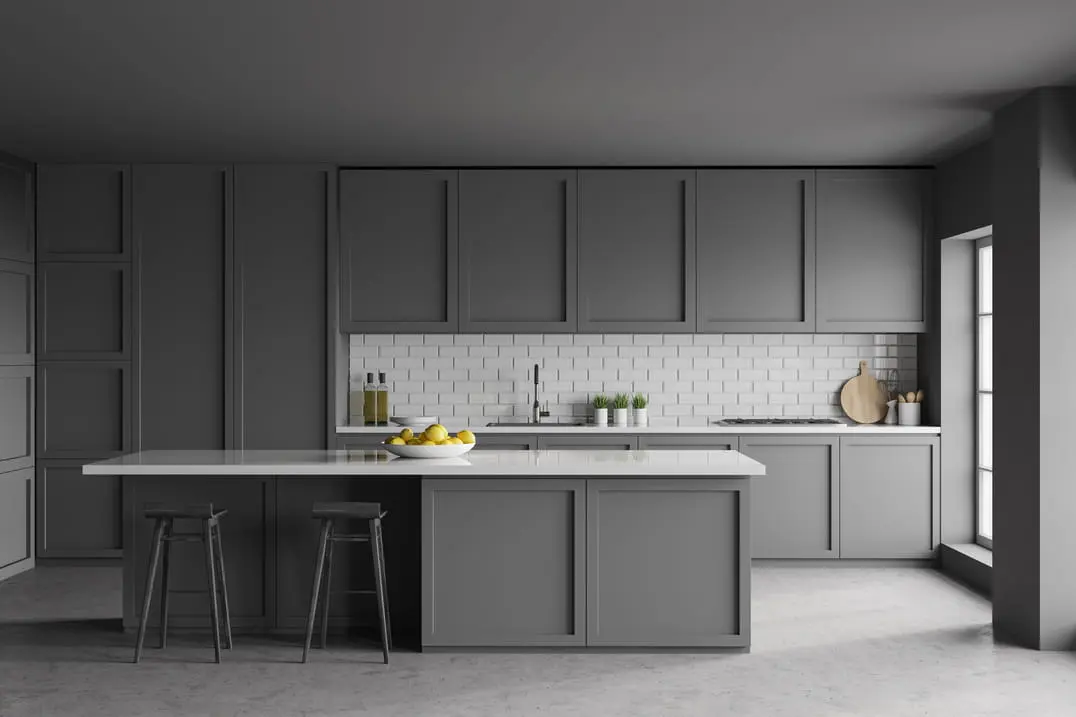 Cocina con armarios de color gris y suelo de microcemento