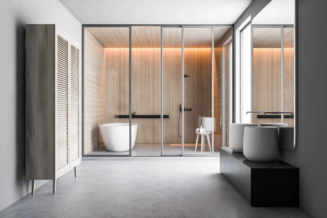 Kamar mandi modern dengan area pancuran termasuk bak mandi dan instalasi mikrosemen abu-abu di atas lantai berpemanas