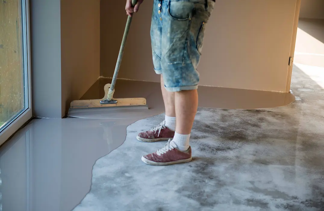 Pekerja menerapkan lantai resin epoxy