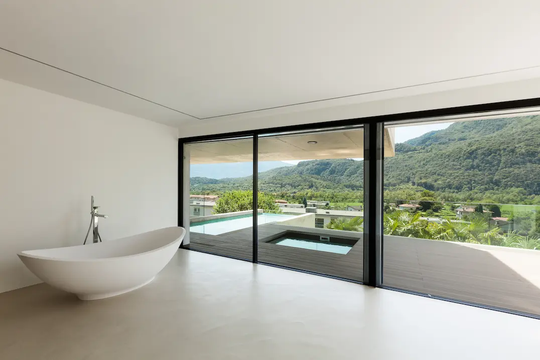 Kamar mandi dengan pemandangan eksterior dan lantai microcemento