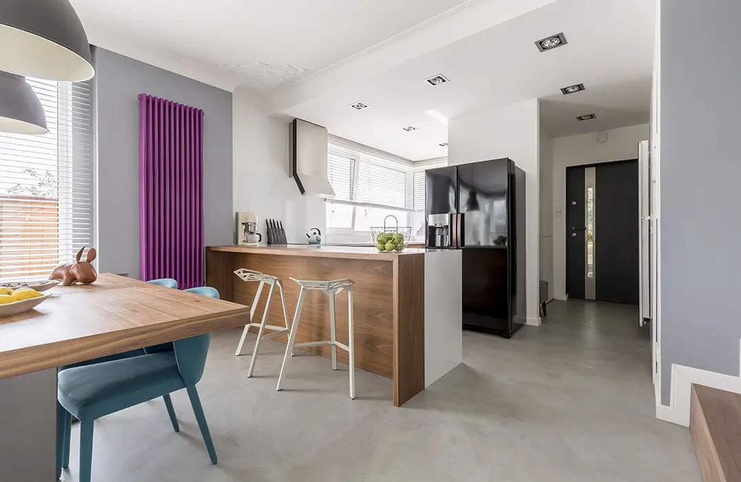 Kjøkken åpent mot spisestue med polert betonggulv