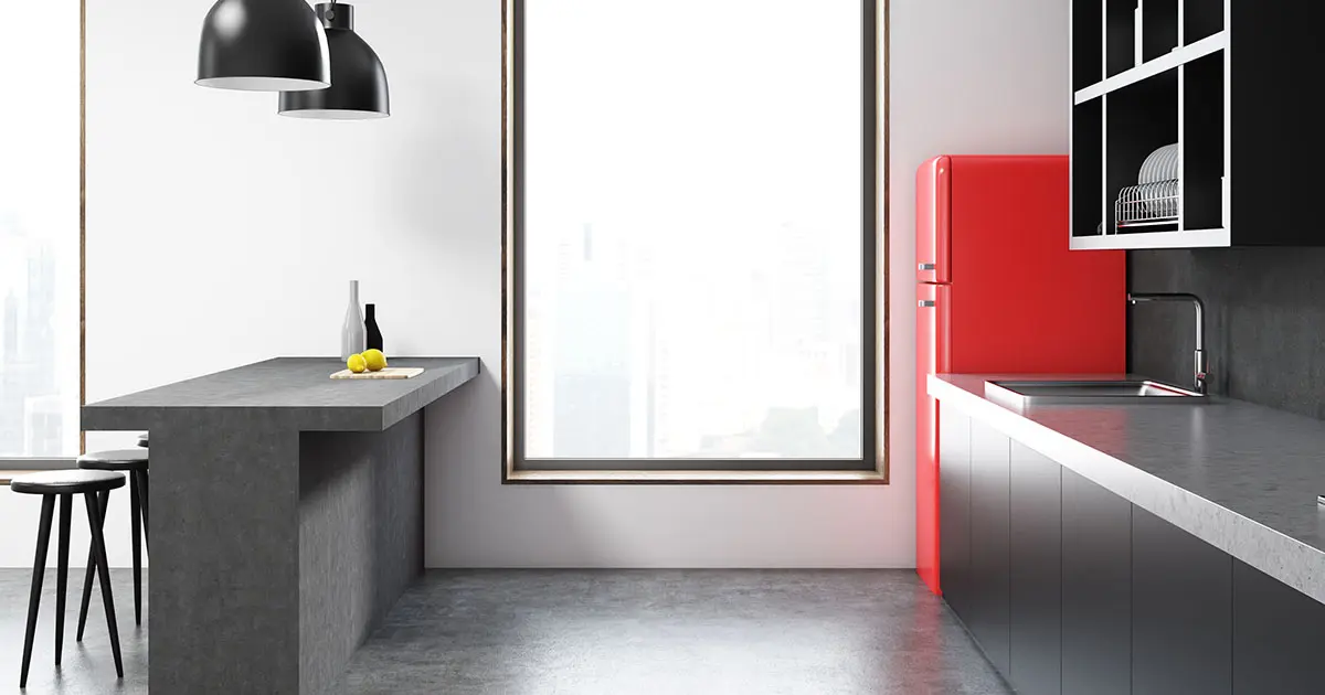 Jasne osvetlená kuchyňa s povrchovou úpravou mikrocementom v sivých tónoch na pracovnej doske a nábytku